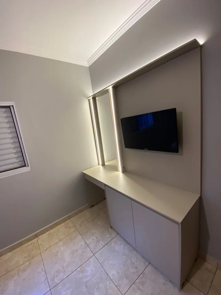 Penteadeira planejada com espelho retangular iluminado por LED e painel para TV