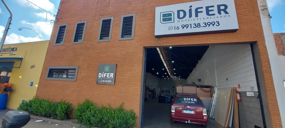 Fachada da Dífer Móveis Planejados em Batatais, em tijolo aparente, com letreiro grande e carro da empresa na entrada do galpão