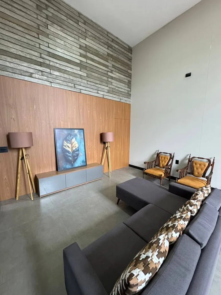 Sala de estar com rack de TV em MDF cinza, parede em ripado de madeira e poltronas estofadas mostarda